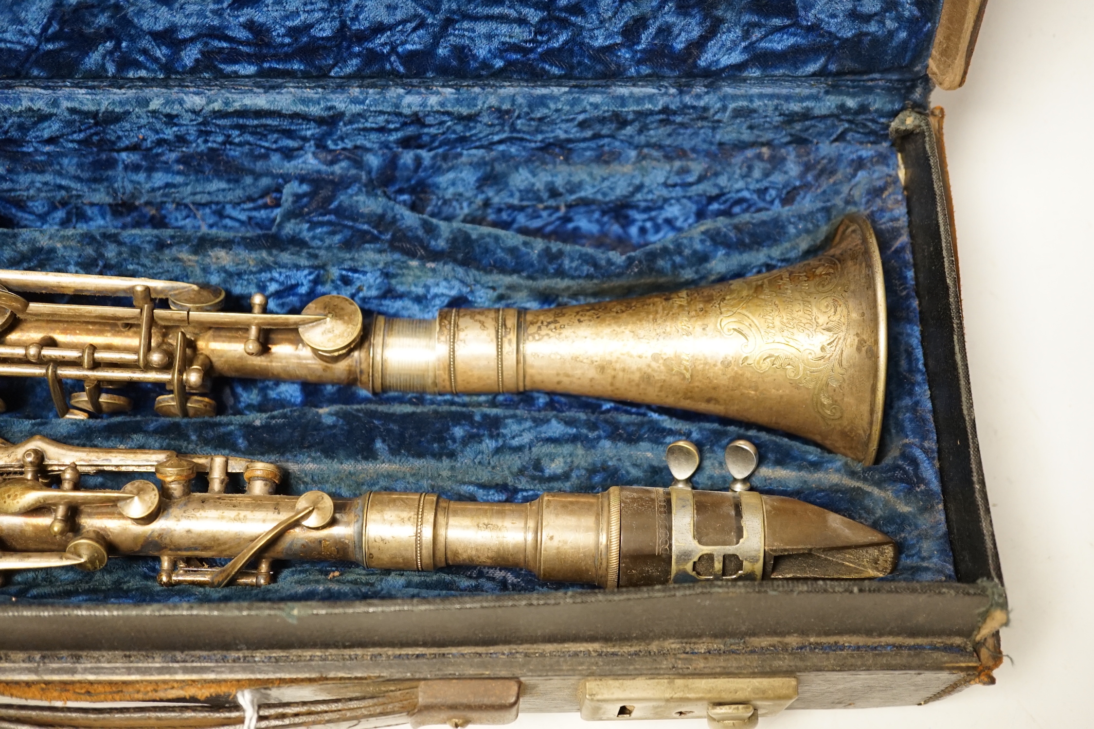 An early 20th century cased Boosey & Hawkes clarinet with plated metal body, bell engraved with ‘Lucian Bassi, British Agents Heywood & Sons, Blackpool’